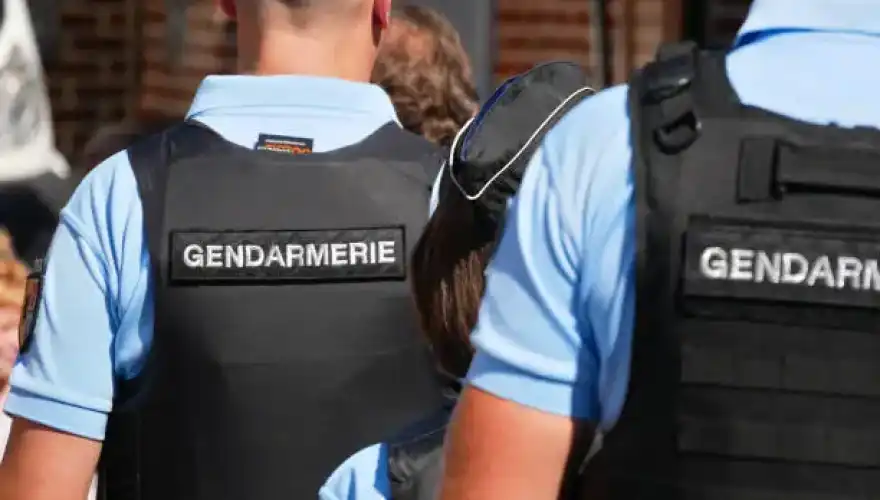Arleux, France - 09 02 2023 : Gendarmes seen from behind wearing bullet-proof vests and gendarmerie bibs